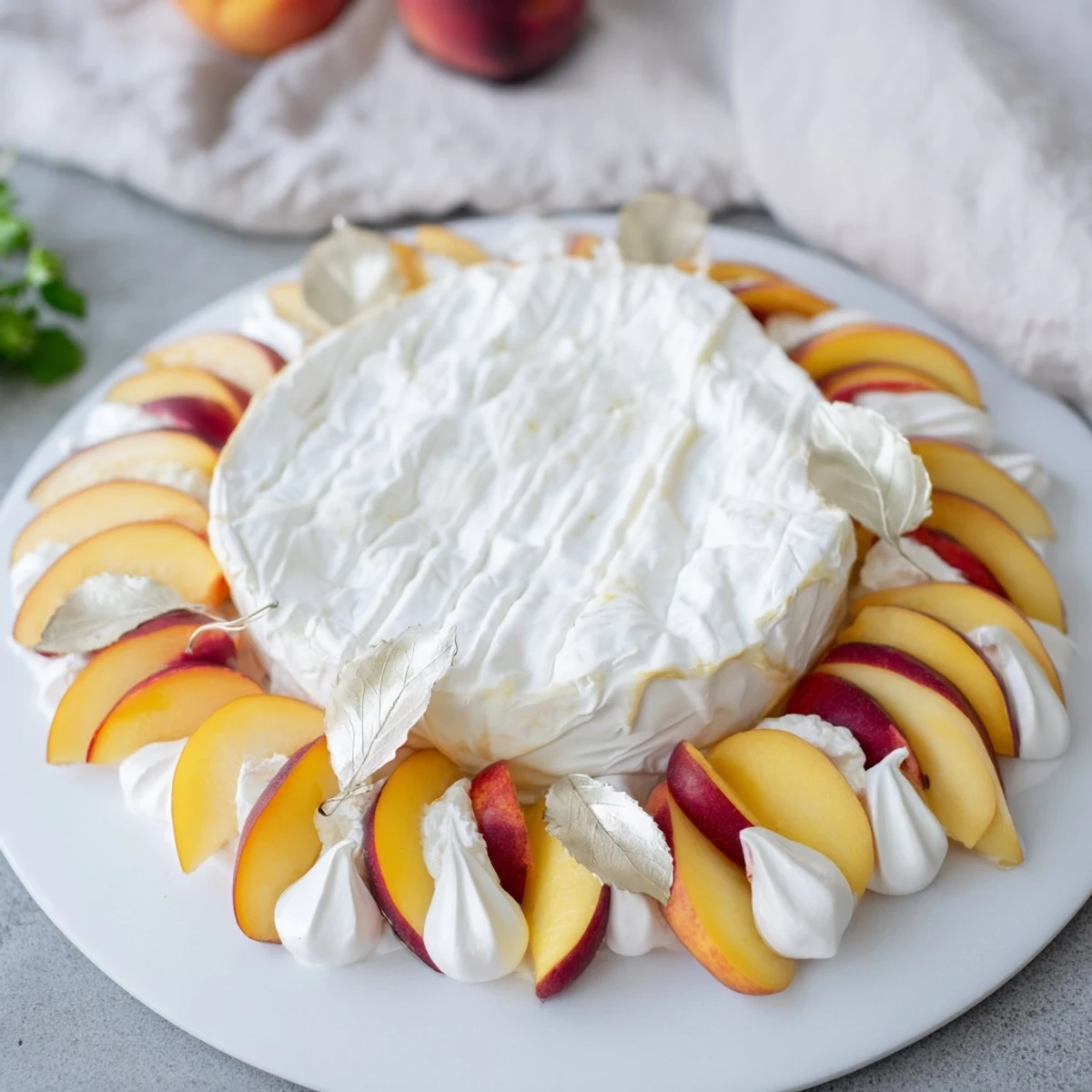 Elegant Pearly Gates cheese board with a starburst of ripe white peaches around a creamy brie wheel.