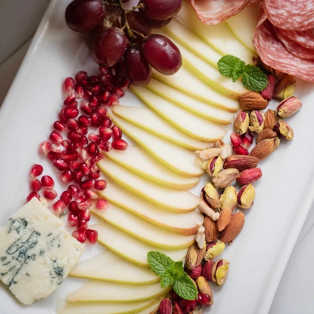 Pomegranate Jewel Cascade cheese board with vibrant red pomegranate seeds and artisan crackers, easy appetizer.