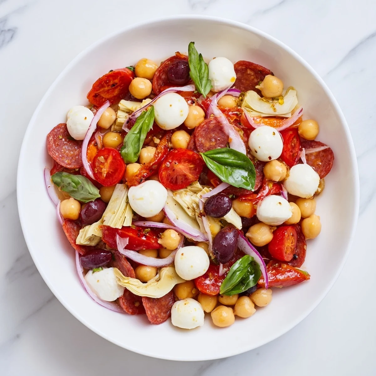 Bright red tomatoes and creamy mozzarella pearls star in this fresh Antipasto Chickpea Salad recipe.