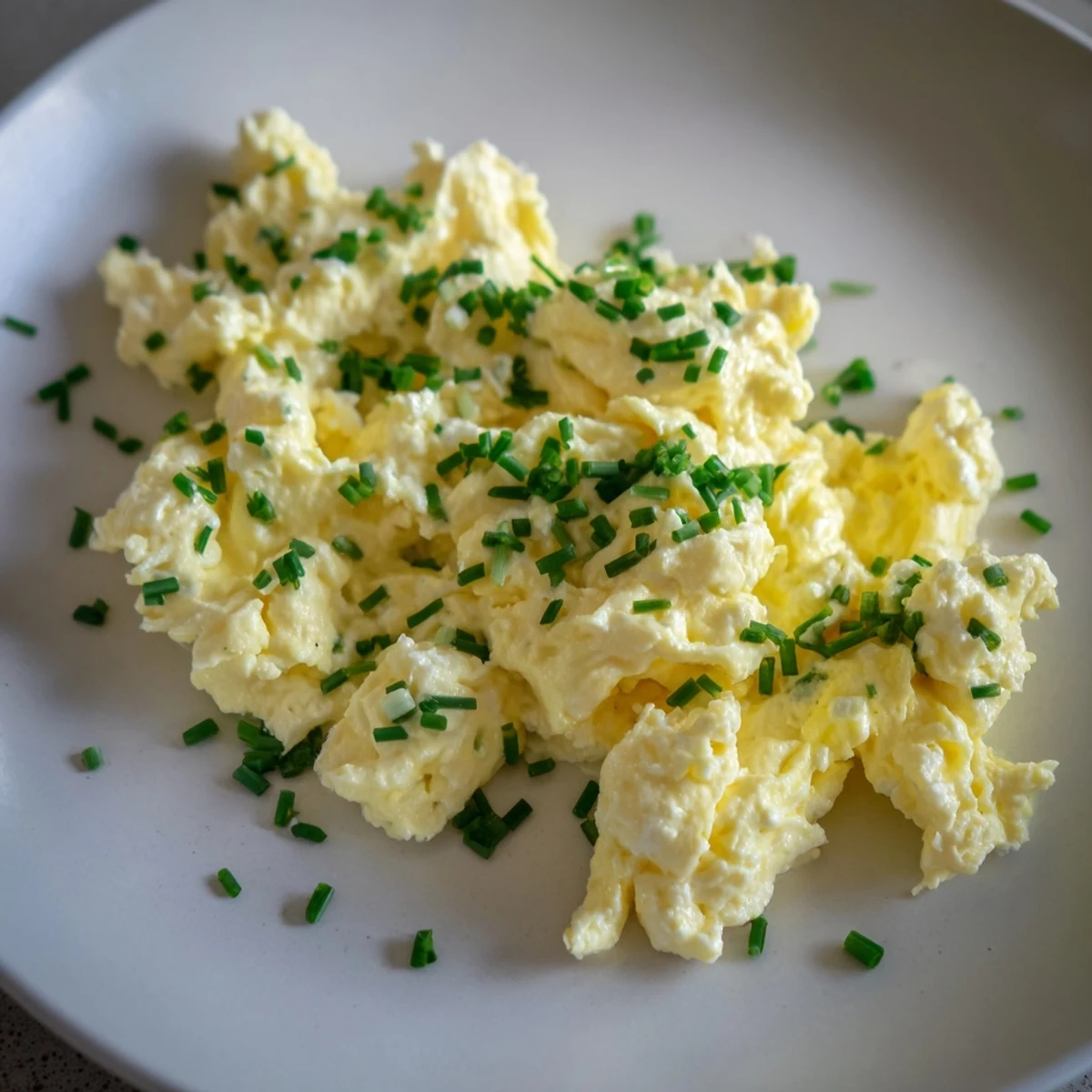 Golden-yellow Cottage Cheese Scrambled Eggs, cooked in butter, offering a creamy and flavorful morning treat.
