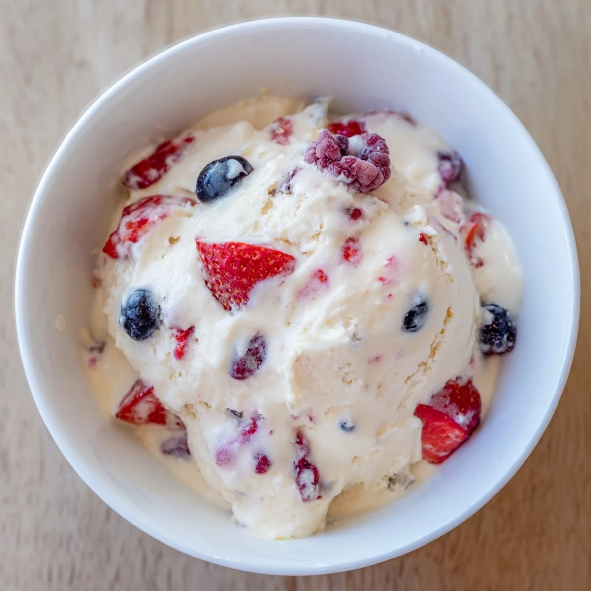 Served in a bowl, a refreshing portion of Cottage Cheese Ice Cream promises a delightful, fruity treat.