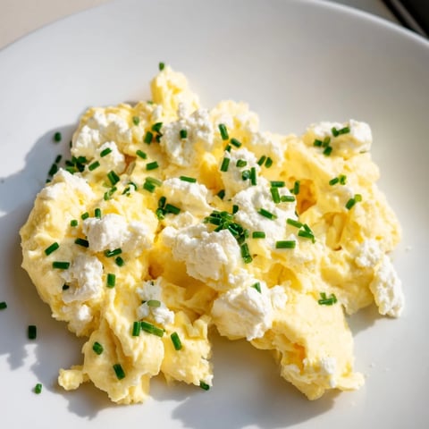 Fluffy Cottage Cheese Scrambled Eggs, a high-protein breakfast, ready with fresh chives sprinkled on top.