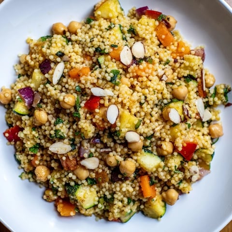 Fluffy Moroccan couscous salad with colorful roasted vegetables and fresh herbs, ready to serve.