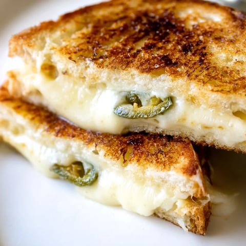 Melting Havarti cheese and spicy jalapeños peek from golden, crispy sourdough slices of Jalapeño Havarti Grilled Cheese.  