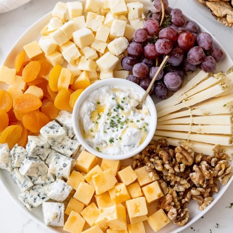 A beautifully arranged Celtic Cross Cheese Platter showcases four cheese varieties with grapes and nuts.