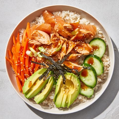 This Japanese-Style Salmon & Chicken Rice Bowl brims with savory marinated chicken and flaky salmon on fluffy rice.