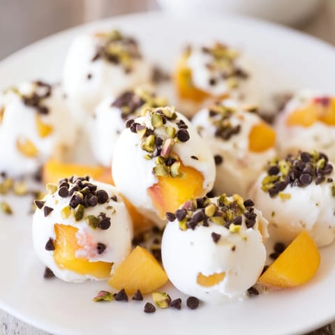 Frozen Peach Yogurt Bites sprinkled with nuts, looking like refreshing, bite-sized frozen desserts.