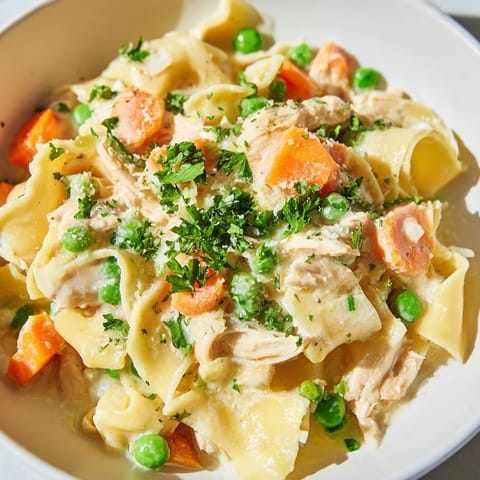 Spring Chicken Noodle Skillet topped with fresh parsley, served in a skillet with golden noodles and colorful spring vegetables.