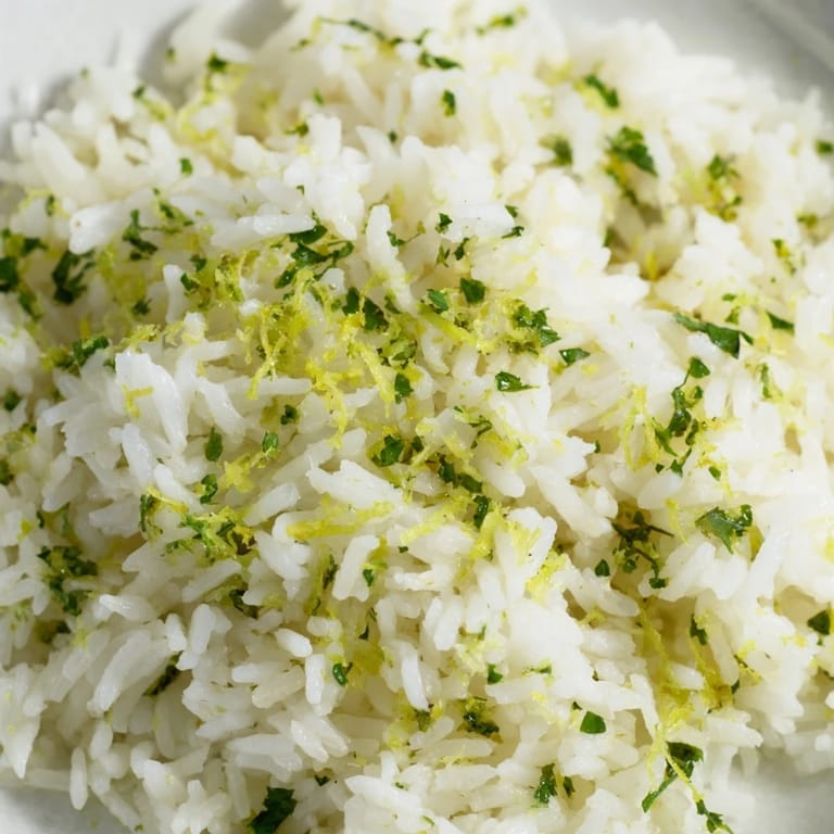 Bright green Cilantro Lime Rice in a white ceramic bowl, served alongside grilled chicken and vibrant roasted vegetables for dinner.