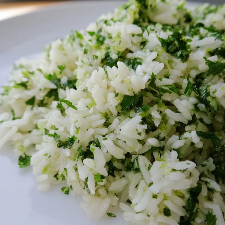 Freshly prepared Cilantro Lime Rice with chopped cilantro and lime zest, steaming beside a colorful plate of Mexican-inspired tacos.