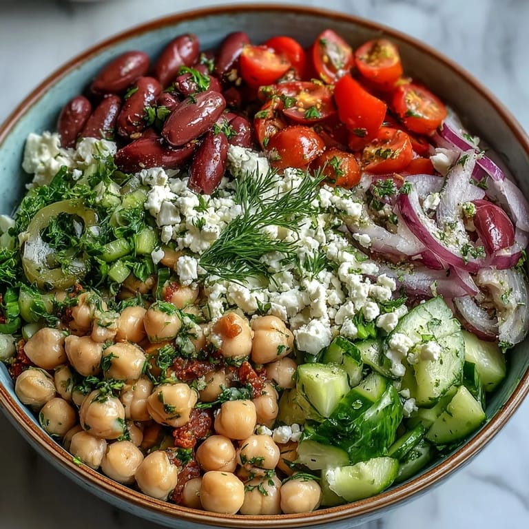 Vibrant vegetarian Greek Bean Salad with creamy feta and glistening lemon dressing, served as a refreshing Mediterranean lunch or picnic side.