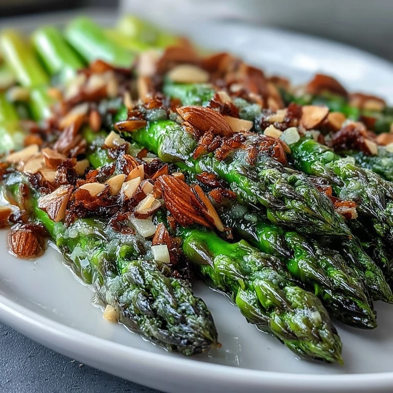 Tender asparagus tossed in zesty lemon butter, finished with crunchy almonds—a vibrant spring vegetable plate.