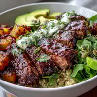Butternut Squash Steak Bowls with tender roasted squash, smoky steak, and fluffy quinoa, drizzled with bright lime-cilantro dressing.