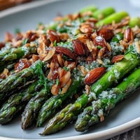 Bright asparagus spears sautéed in lemon butter, topped with toasted almonds for a fresh, elegant side dish.
